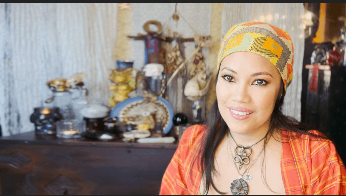 Rannie smiling in front of magickal items